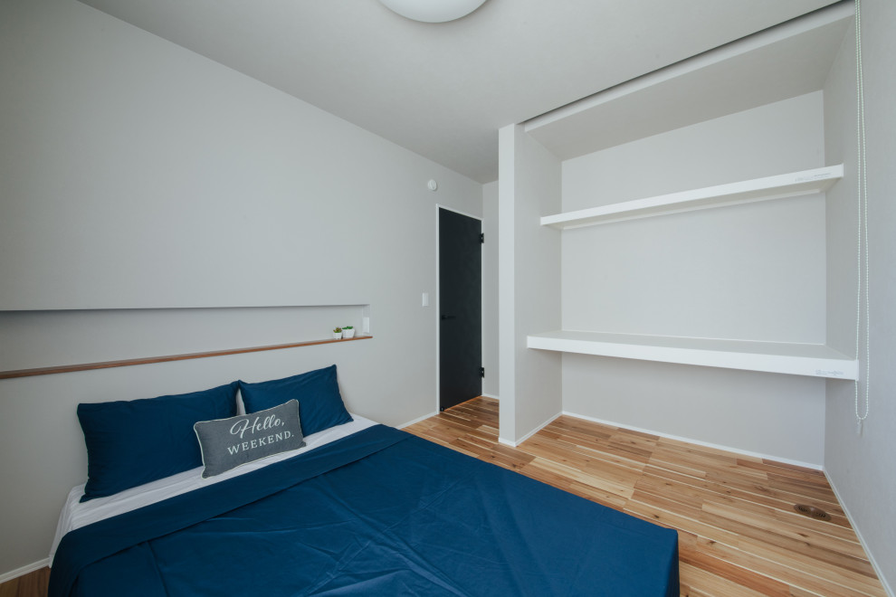 Aménagement d'une chambre parentale contemporaine avec un mur blanc, un sol en bois brun, aucune cheminée, un sol beige, un plafond en papier peint et du papier peint.