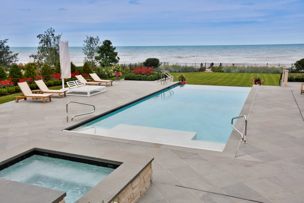 Photo of a mid-sized traditional courtyard rectangular lap pool in Chicago with with a pool and natural stone pavers.