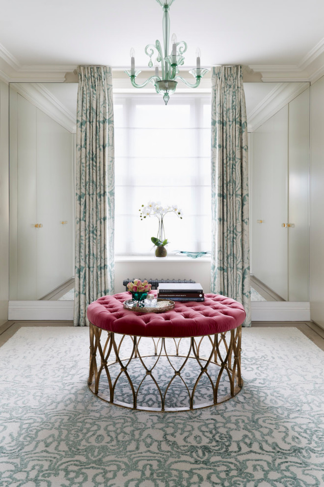 Large traditional dressing room for women in London with flat-panel cabinets and beige cabinets.