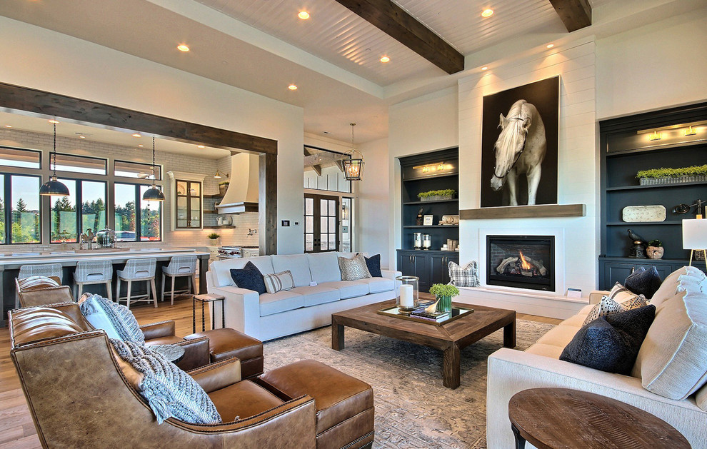 Inspiration for an expansive country open concept family room in Portland with a home bar, beige walls, light hardwood floors, a standard fireplace, no tv and brown floor.