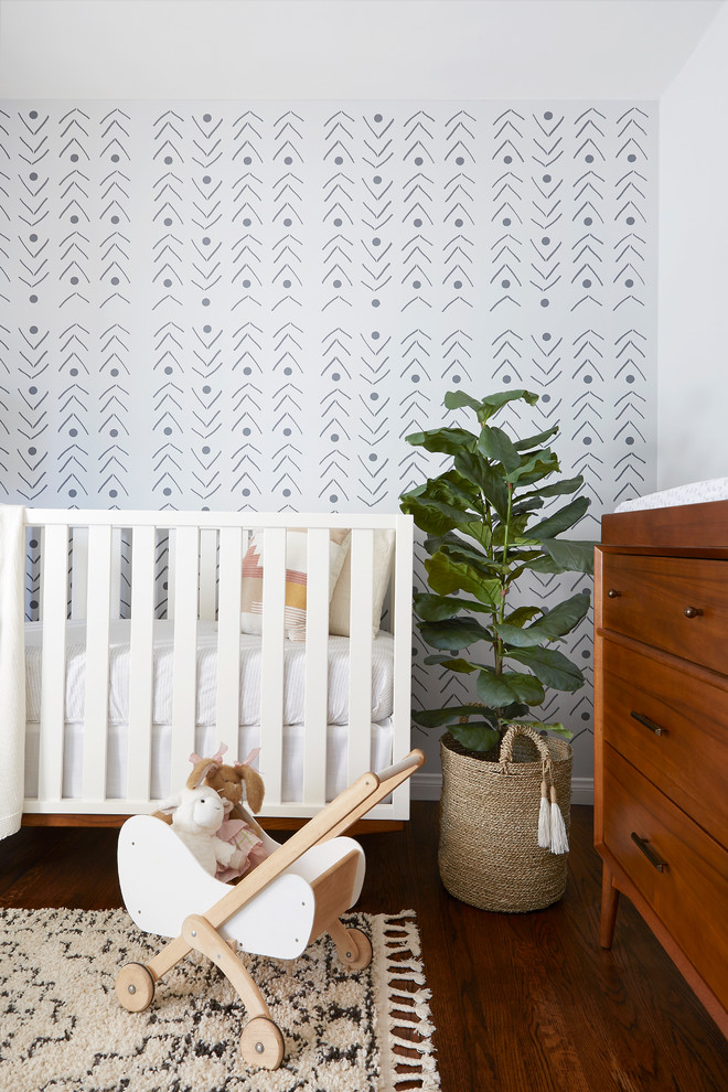 This is an example of a mid-sized scandinavian nursery for girls in Los Angeles with grey walls, dark hardwood floors and brown floor.