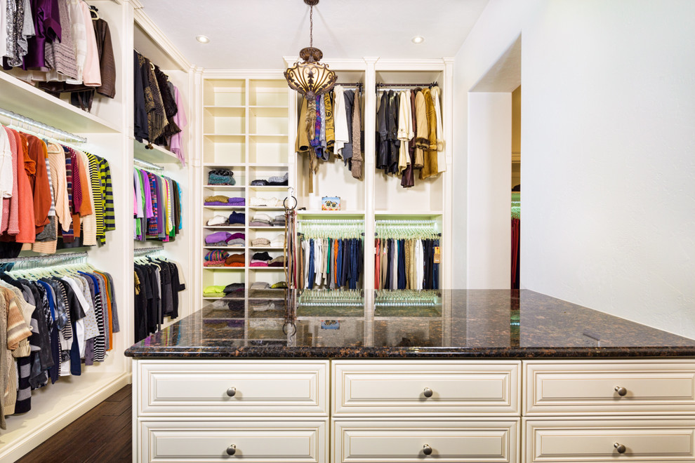 Photo of a large traditional gender-neutral walk-in wardrobe in Tampa with open cabinets, dark hardwood floors and beige cabinets.