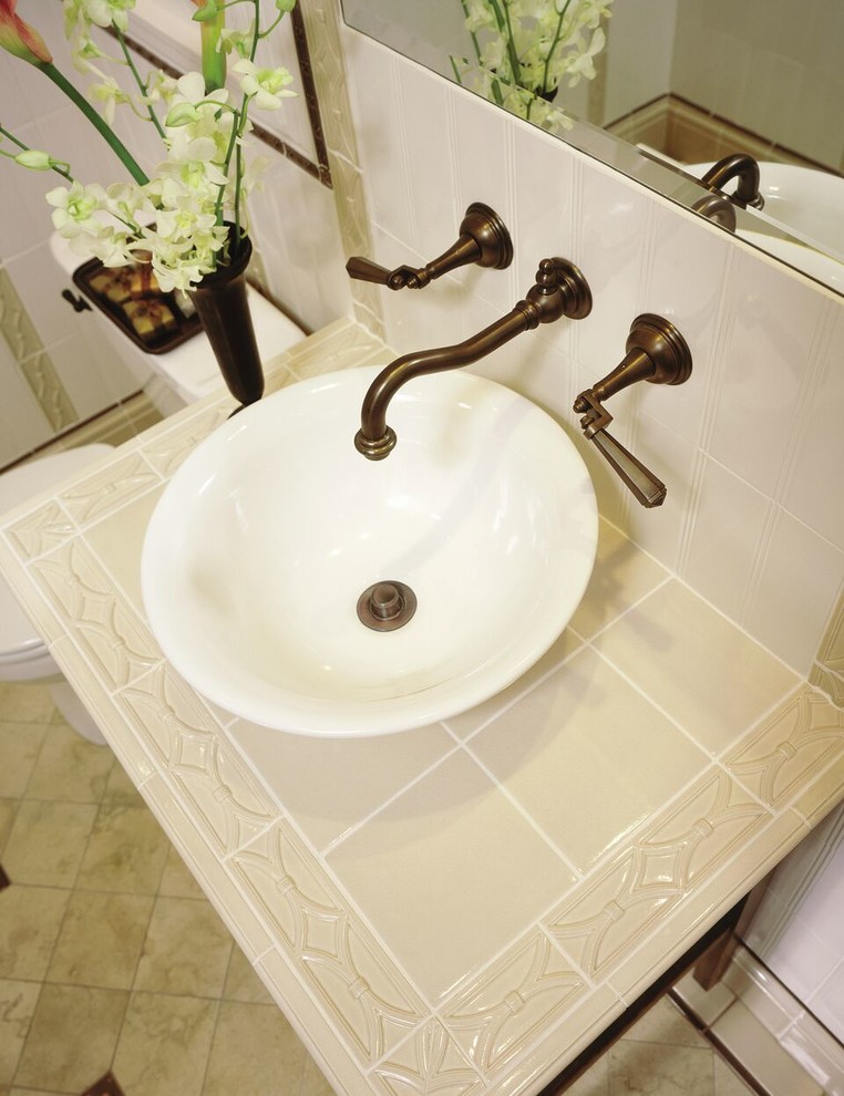 Inspiration for a mid-sized transitional beige tile bathroom remodel with flat-panel cabinets, dark wood cabinets, beige walls, a vessel sink and tile countertops