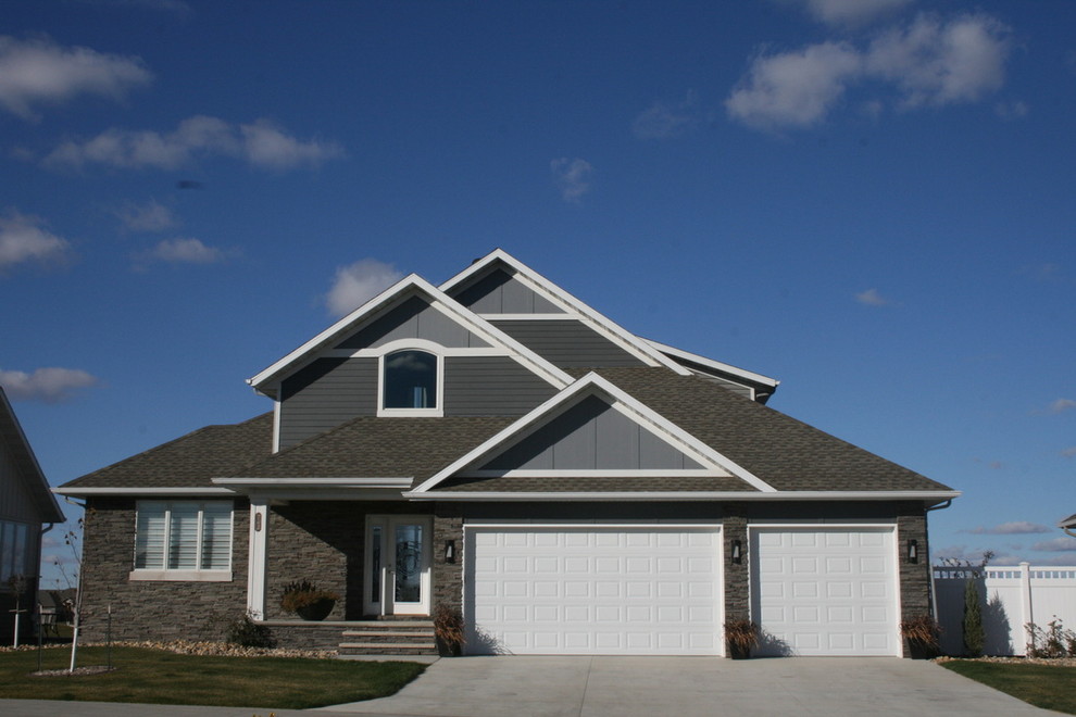 This is an example of a modern two-storey grey exterior in Other with mixed siding and a gable roof.
