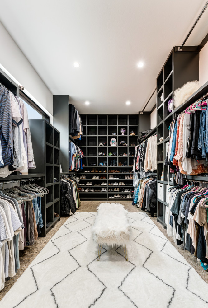 Design ideas for a large contemporary gender neutral built-in wardrobe in Dallas with open cabinets, black cabinets, concrete flooring and grey floors.
