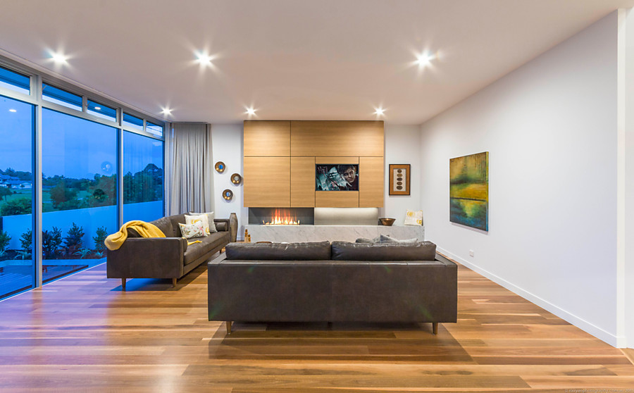 Living room in Gold Coast - Tweed with white walls, medium hardwood floors, a wood fireplace surround, a built-in media wall and a ribbon fireplace.