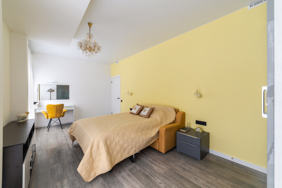 Immagine di una grande camera matrimoniale minimalista con pareti gialle, pavimento in laminato, nessun camino, pavimento marrone e soffitto ribassato