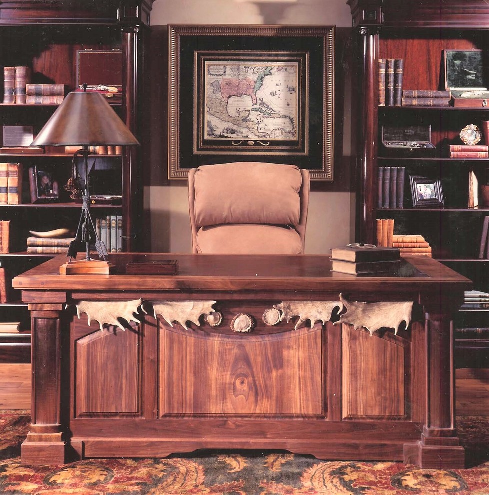 This is an example of a mid-sized country study room in Denver with beige walls, medium hardwood floors, no fireplace, a freestanding desk and brown floor.