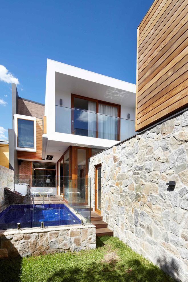 This is an example of a mid-sized contemporary two-storey exterior in Sydney with mixed siding and a flat roof.