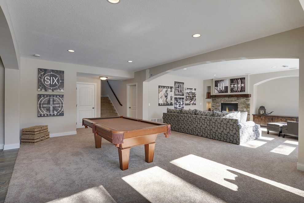 Design ideas for a large transitional walk-out basement in Minneapolis with grey walls, carpet, a standard fireplace and a stone fireplace surround.