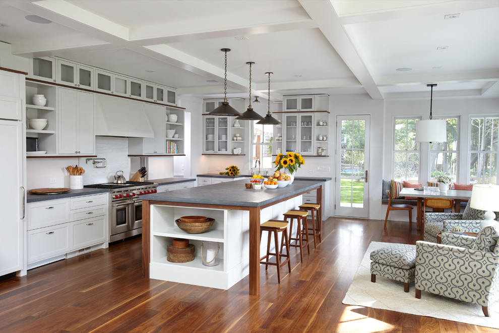 Inspiration for a transitional l-shaped medium tone wood floor and brown floor kitchen remodel in Miami with shaker cabinets, white cabinets, stainless steel appliances, an island and gray countertops