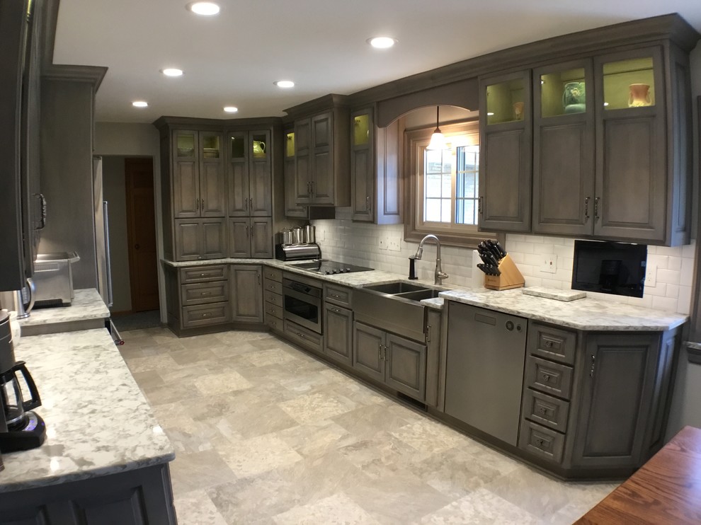 Design ideas for a mid-sized traditional kitchen in Cleveland with a farmhouse sink, raised-panel cabinets, grey cabinets, quartz benchtops, white splashback, subway tile splashback, stainless steel appliances, vinyl floors and multi-coloured floor.