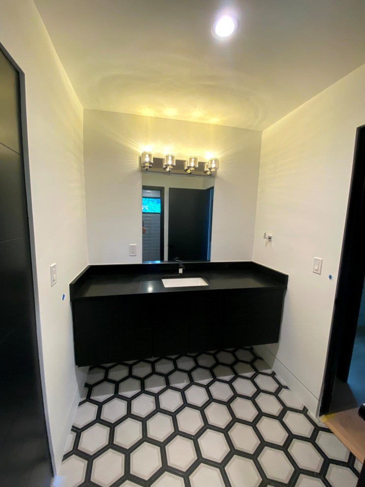 Photo of a mid-sized modern wet room bathroom in Other with flat-panel cabinets, black cabinets, a two-piece toilet, white tile, white walls, porcelain floors, with a sauna, a drop-in sink, onyx benchtops, white floor, an open shower, black benchtops, a single vanity and a floating vanity.