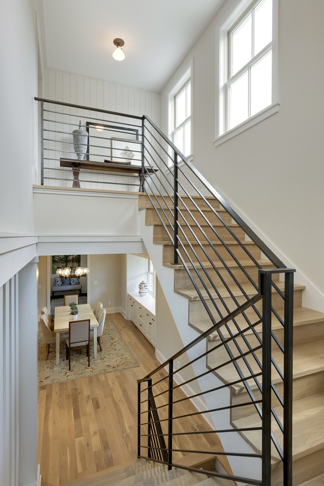 Design ideas for a mid-sized country wood u-shaped staircase in Minneapolis with wood risers.