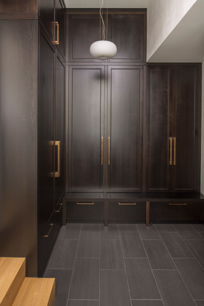 Inspiration for a modern storage and wardrobe in Minneapolis with shaker cabinets, dark wood cabinets, ceramic floors and black floor.