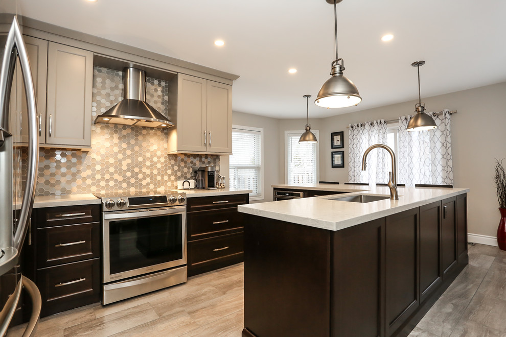 Inspiration for a mid-sized transitional l-shaped porcelain tile enclosed kitchen remodel in Toronto with an undermount sink, recessed-panel cabinets, dark wood cabinets, quartz countertops, gray backsplash, mosaic tile backsplash, stainless steel appliances and an island