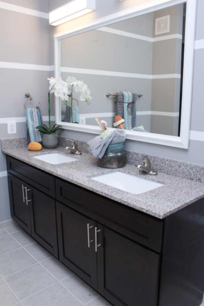 Inspiration for a small contemporary master bathroom in DC Metro with recessed-panel cabinets, dark wood cabinets, granite benchtops, a corner shower, a one-piece toilet, gray tile, ceramic tile, grey walls and ceramic floors.
