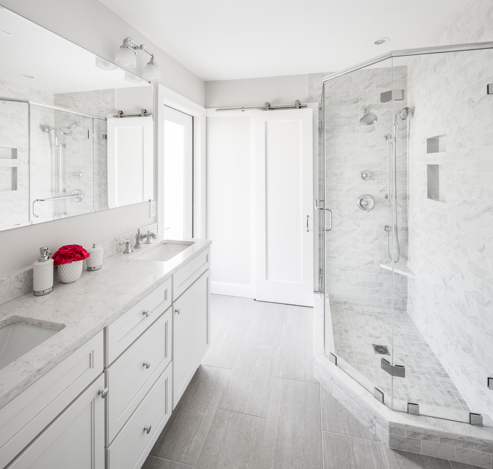 Inspiration for a mid-sized transitional 3/4 bathroom in Boston with shaker cabinets, white cabinets, a corner shower, a two-piece toilet, gray tile, white tile, marble, grey walls, vinyl floors, an undermount sink, quartzite benchtops, grey floor and a hinged shower door.