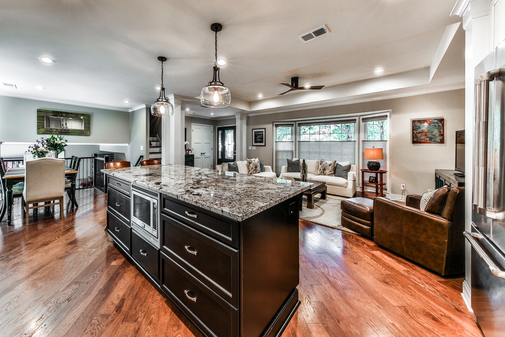 Example of a large transitional l-shaped medium tone wood floor open concept kitchen design in Atlanta with an undermount sink, shaker cabinets, white cabinets, granite countertops, white backsplash, subway tile backsplash, stainless steel appliances and an island