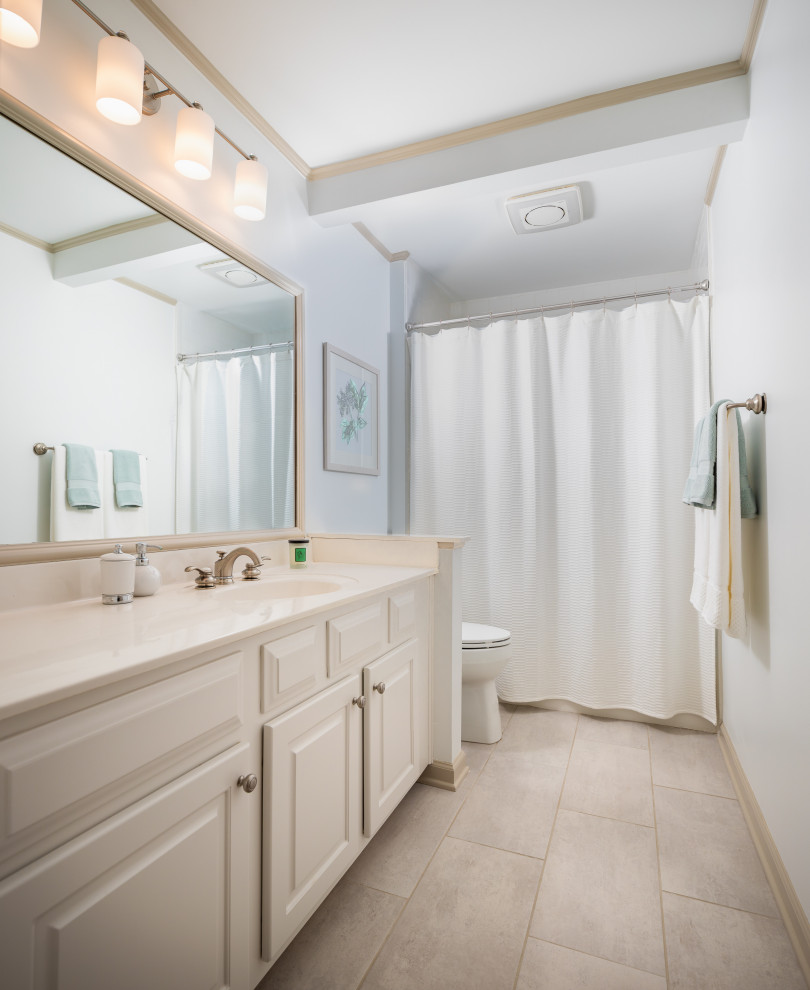 Design ideas for a transitional bathroom in Atlanta with raised-panel cabinets, beige cabinets, a shower/bathtub combo, white tile, porcelain tile, white walls, porcelain floors, solid surface benchtops, beige floor, white benchtops, a single vanity and a built-in vanity.