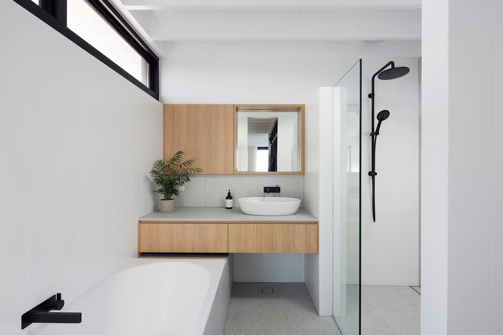 Inspiration for a contemporary 3/4 bathroom in Sydney with flat-panel cabinets, medium wood cabinets, a drop-in tub, a curbless shower, gray tile, white walls, a vessel sink, grey floor, an open shower and grey benchtops.