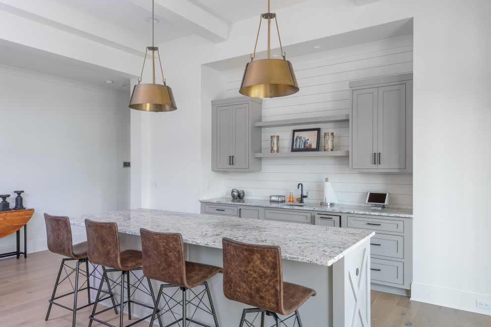 Inspiration for a transitional galley home bar in Other with an undermount sink, shaker cabinets, grey cabinets, white splashback, shiplap splashback, medium hardwood floors, brown floor and grey benchtop.