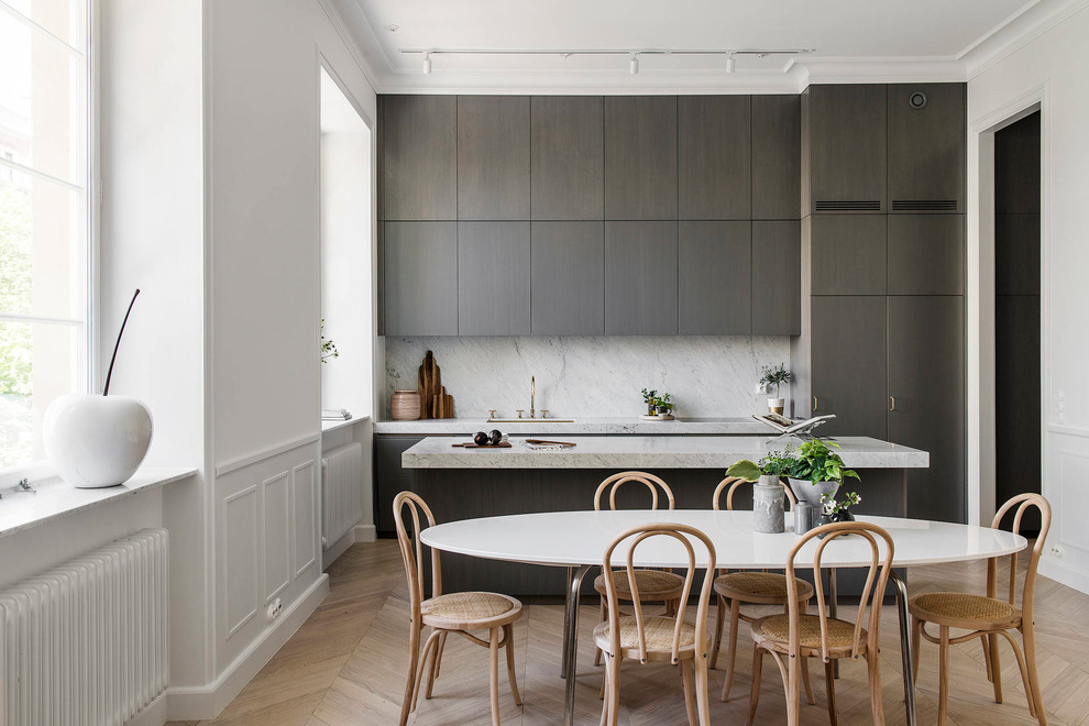 This is an example of a scandinavian single-wall eat-in kitchen in Stockholm with an undermount sink, flat-panel cabinets, grey cabinets, grey splashback, light hardwood floors, with island, beige floor and grey benchtop.