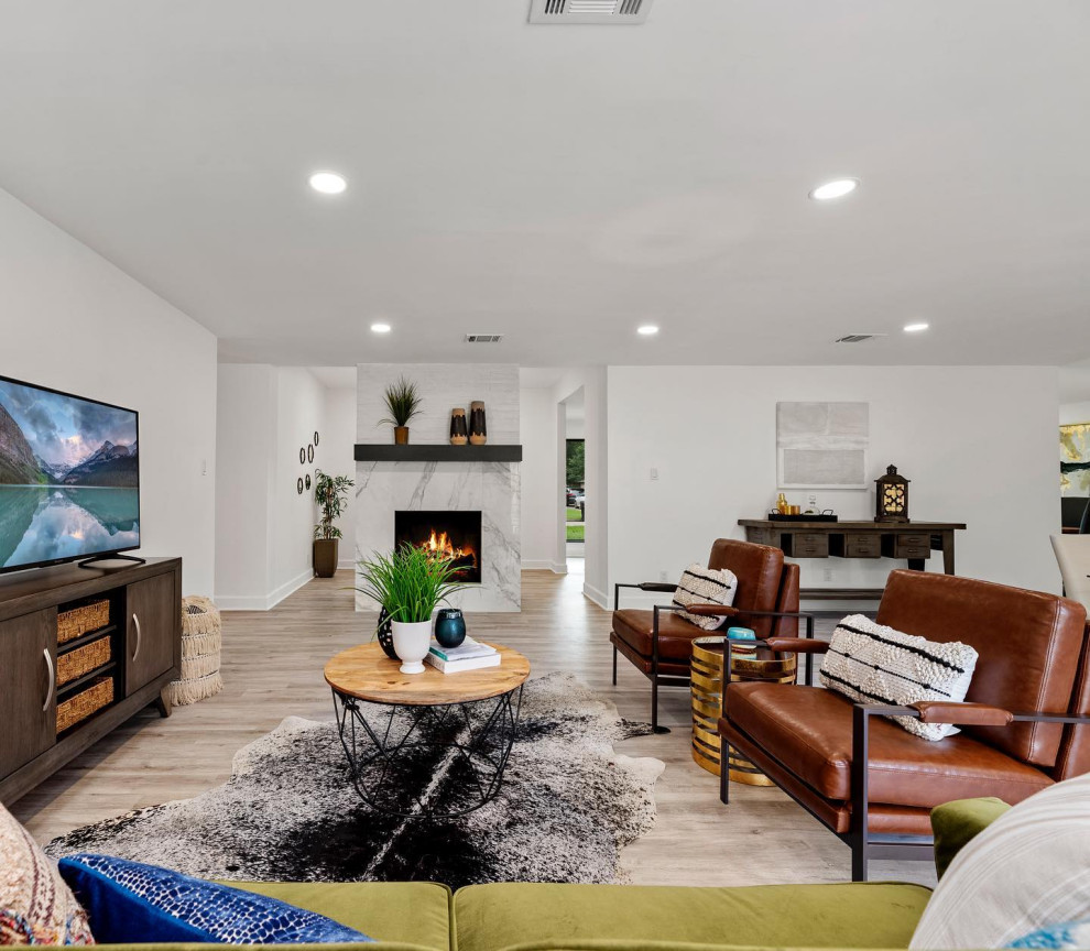 Foto di un soggiorno design di medie dimensioni e aperto con pareti bianche, camino classico, cornice del camino in mattoni e pavimento beige