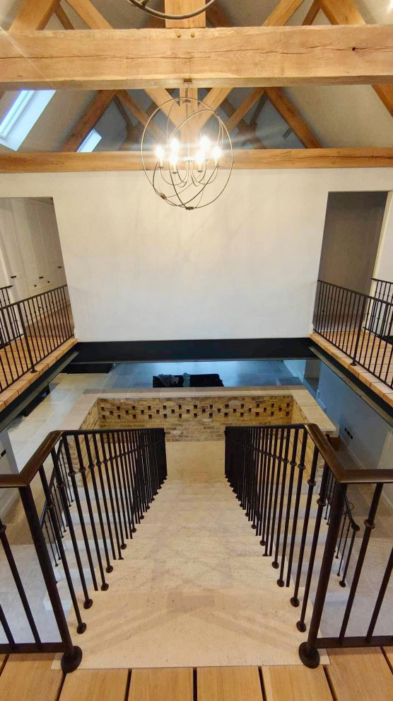 Mid-sized modern travertine floating staircase in Other with travertine risers and metal railing.