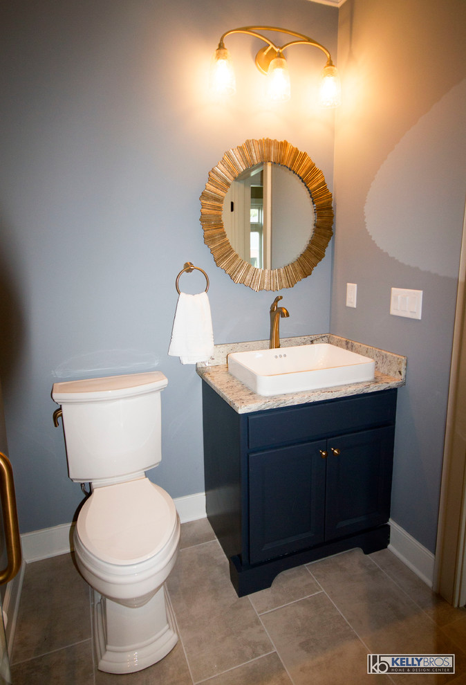Photo of a small transitional powder room in Cincinnati with blue cabinets, granite benchtops, shaker cabinets, a two-piece toilet, blue walls, ceramic floors, a vessel sink and grey floor.