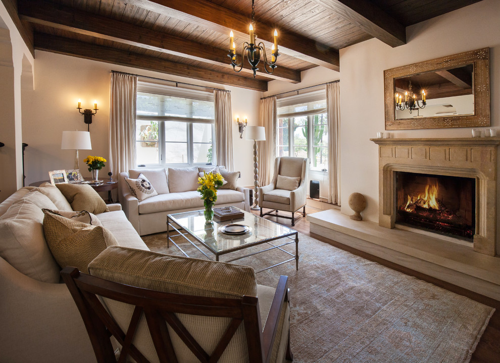 This is an example of a mid-sized mediterranean open concept living room in Santa Barbara with white walls, dark hardwood floors, a standard fireplace and a stone fireplace surround.