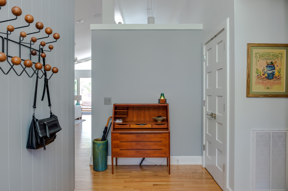 Immagine di un ingresso o corridoio minimalista di medie dimensioni con pareti grigie, pavimento in legno massello medio, pavimento beige, soffitto a volta e pannellatura