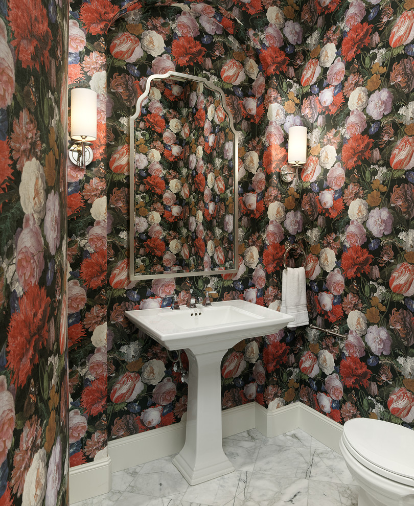 This is an example of a traditional powder room in Dallas with multi-coloured walls, a pedestal sink, white floor, a one-piece toilet and wallpaper.
