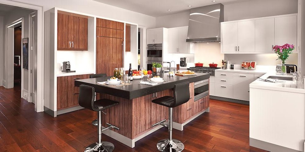 This is an example of a large modern u-shaped kitchen in Miami with an undermount sink, flat-panel cabinets, white cabinets, solid surface benchtops, panelled appliances, dark hardwood floors, with island and brown floor.