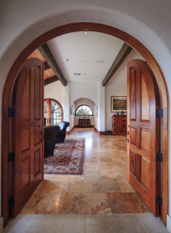 Photo of a mid-sized mediterranean entry hall in Orlando with white walls, travertine floors, a double front door and a medium wood front door.