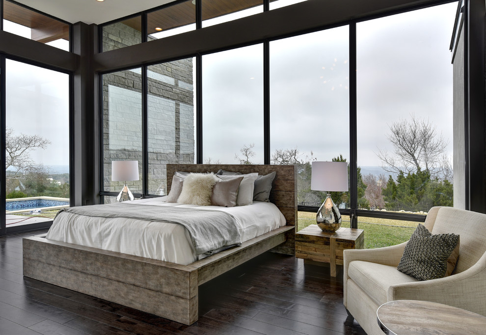 This is an example of a contemporary master bedroom in Austin with black walls, dark hardwood floors and no fireplace.