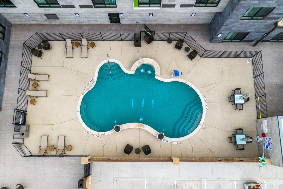 На фото: огромный естественный бассейн произвольной формы на внутреннем дворе в стиле рустика с перегородкой для приватности и мощением тротуарной плиткой