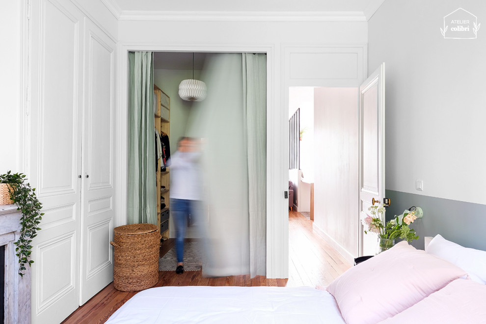 Idées déco pour une chambre parentale scandinave de taille moyenne avec un mur vert, parquet clair, une cheminée standard, un manteau de cheminée en pierre et un sol marron.