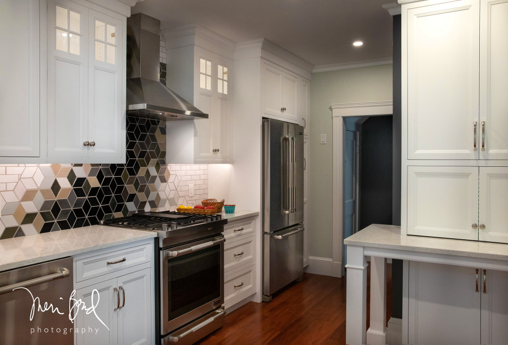 Open concept kitchen - mid-sized transitional l-shaped dark wood floor and brown floor open concept kitchen idea in Minneapolis with a drop-in sink, beaded inset cabinets, white cabinets, quartzite countertops, multicolored backsplash, ceramic backsplash, stainless steel appliances, an island and white countertops