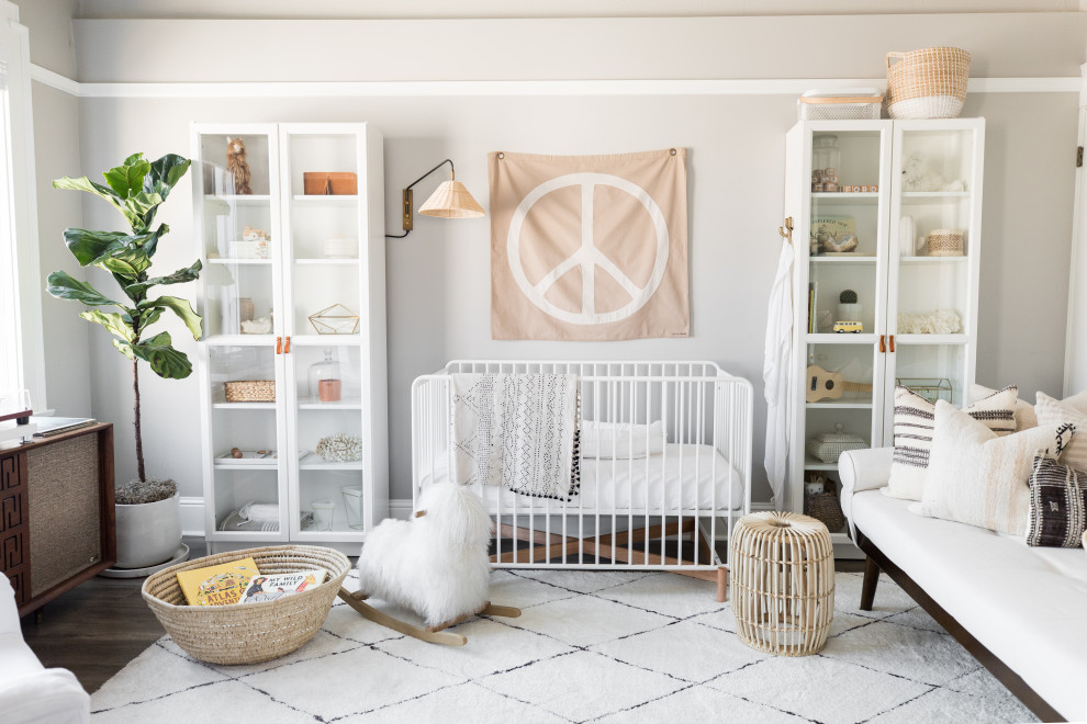 This is an example of a transitional nursery in Sacramento with grey walls, dark hardwood floors and brown floor.