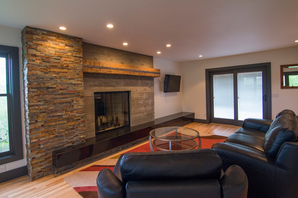 Mid-sized contemporary open concept living room in Milwaukee with white walls, light hardwood floors, a standard fireplace, a concrete fireplace surround and a wall-mounted tv.