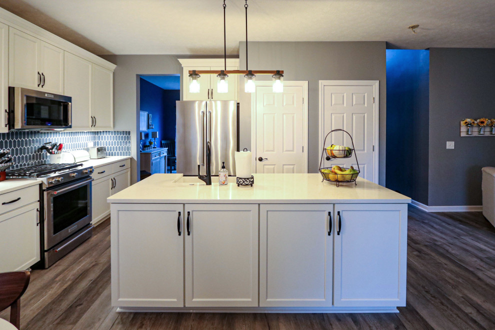 Exempel på ett mellanstort klassiskt vit vitt kök, med en rustik diskho, släta luckor, vita skåp, bänkskiva i kvarts, blått stänkskydd, stänkskydd i keramik, rostfria vitvaror, mellanmörkt trägolv, en köksö och brunt golv