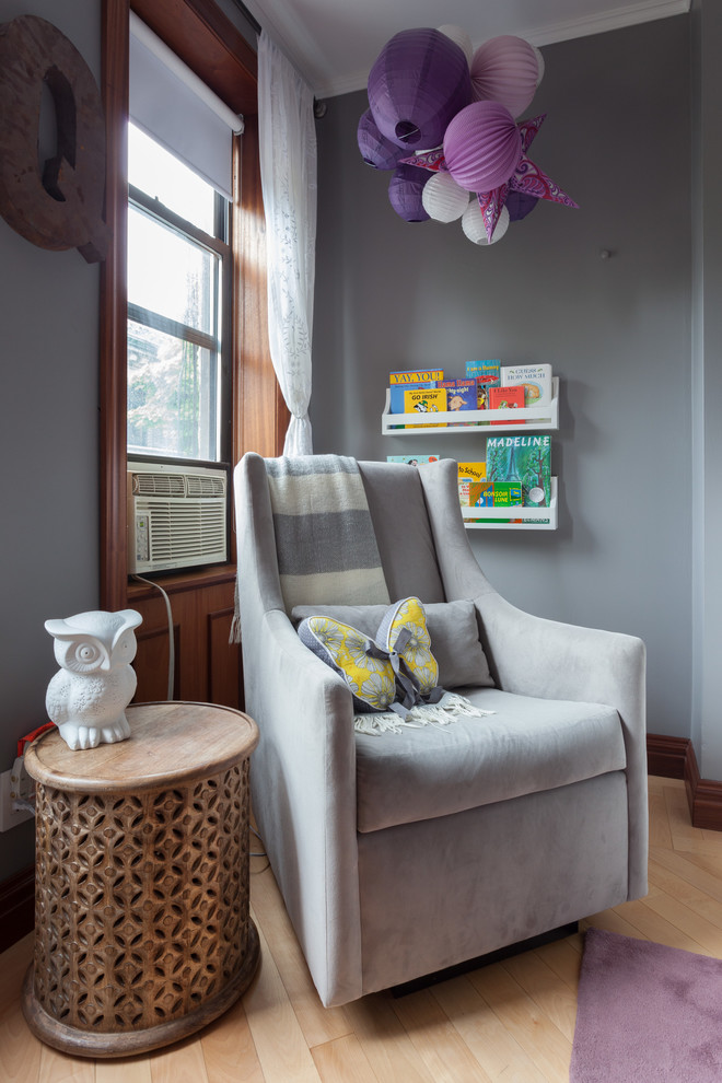 Inspiration for a mid-sized eclectic nursery for girls in New York with grey walls and light hardwood floors.