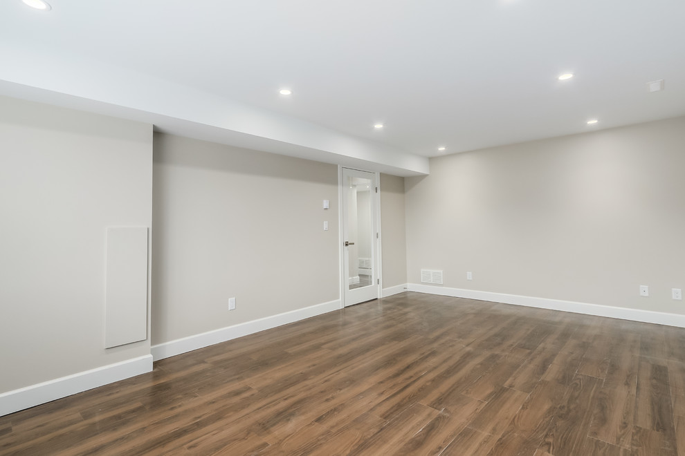 Large transitional walk-out dark wood floor basement photo in Vancouver with beige walls and no fireplace
