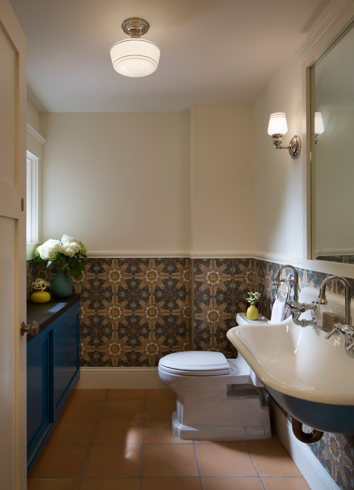 Photo of a large transitional 3/4 bathroom in Orange County with a one-piece toilet, ceramic floors, a wall-mount sink, recessed-panel cabinets, blue cabinets, multi-coloured tile, ceramic tile and soapstone benchtops.