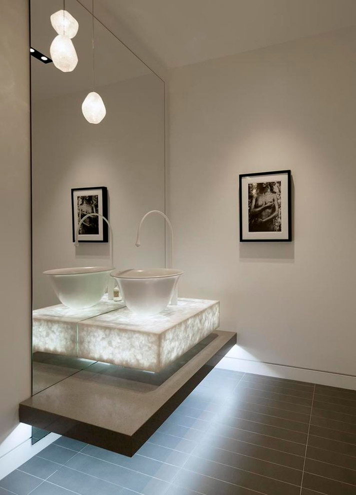 Expansive contemporary powder room in Los Angeles with white walls, porcelain floors, a one-piece toilet, gray tile and a vessel sink.