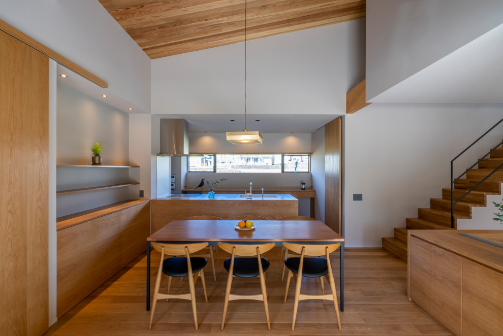 Réalisation d'une salle à manger ouverte sur le salon minimaliste avec un mur blanc, un sol en bois brun, un poêle à bois, un manteau de cheminée en béton, un sol beige, un plafond en bois et du papier peint.