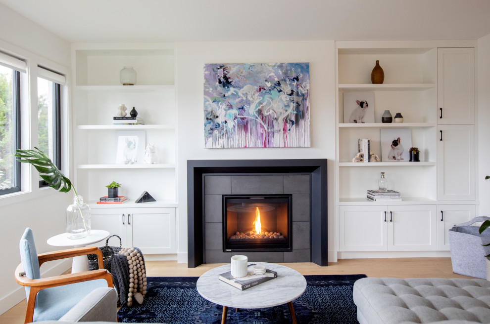 Photo of a large contemporary open plan living room in Vancouver with white walls, a standard fireplace, a metal fireplace surround and beige floors.