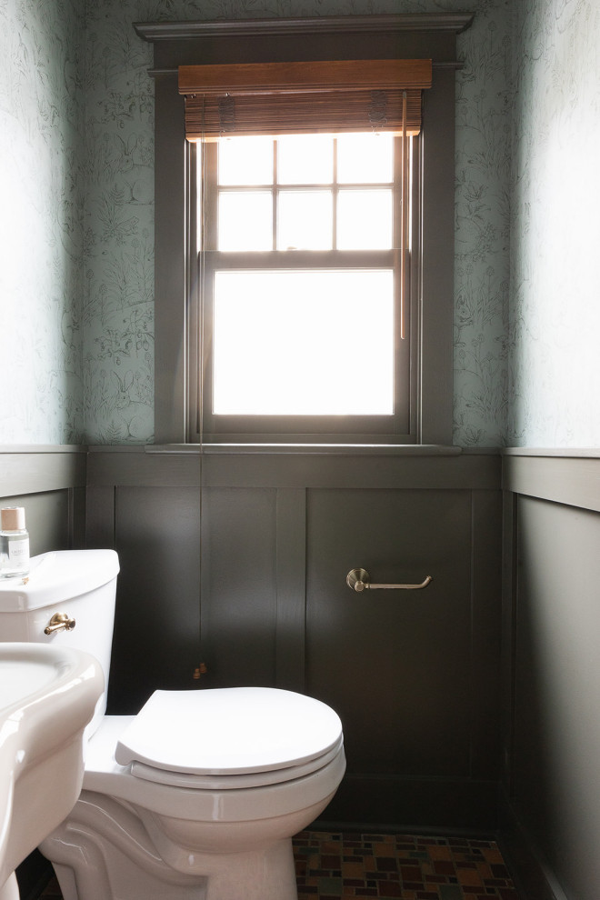 Cette image montre un petit WC et toilettes traditionnel avec un mur vert, un sol en carrelage de céramique, un plan vasque, un sol multicolore, meuble-lavabo sur pied et boiseries.