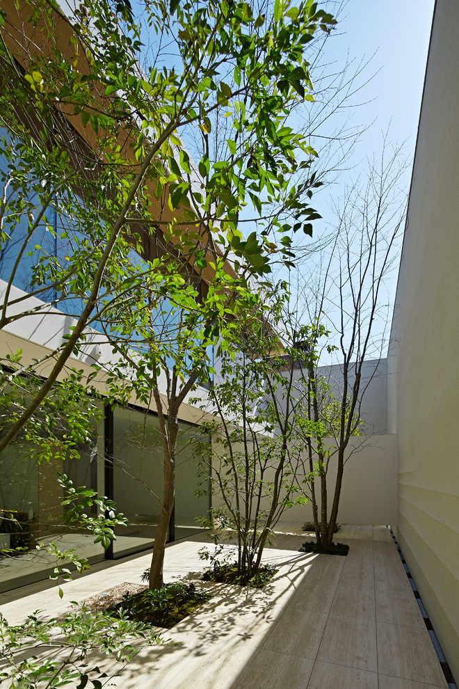 Modern courtyard patio in Tokyo with natural stone pavers.